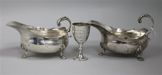 A pair of Edwardian silver sauce boats and a small trophy cup, (one sauceboat a.f.).